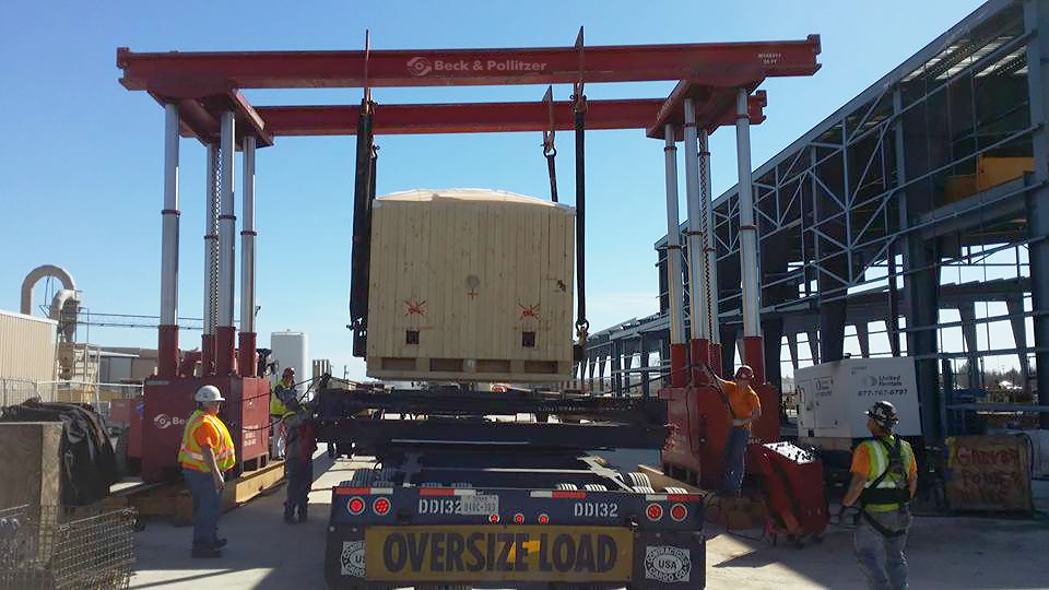 Beck & Pollitzer employees lifting heavy equipment using a gantry system